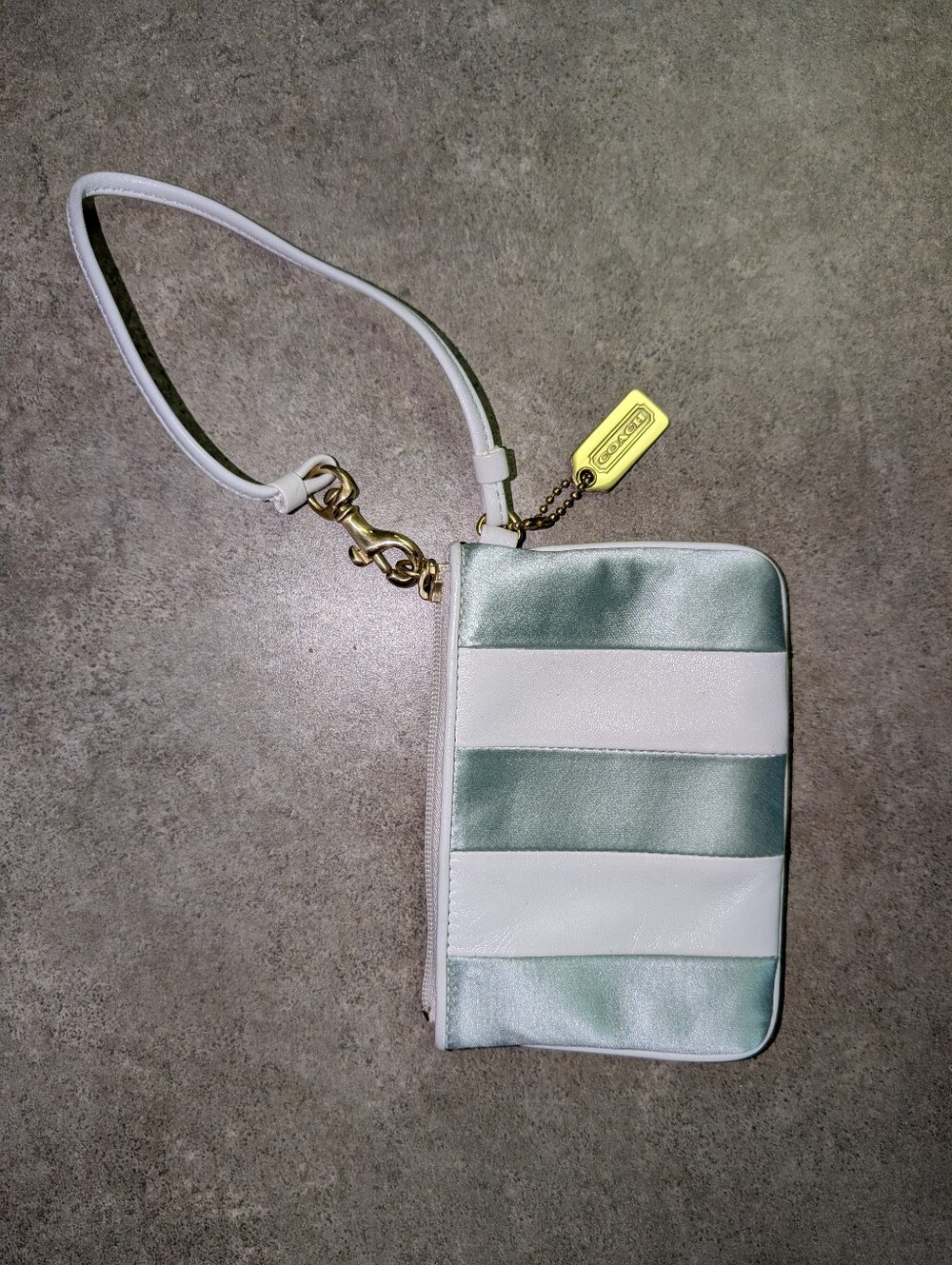 Blue-green and white Coach wristlet purse
